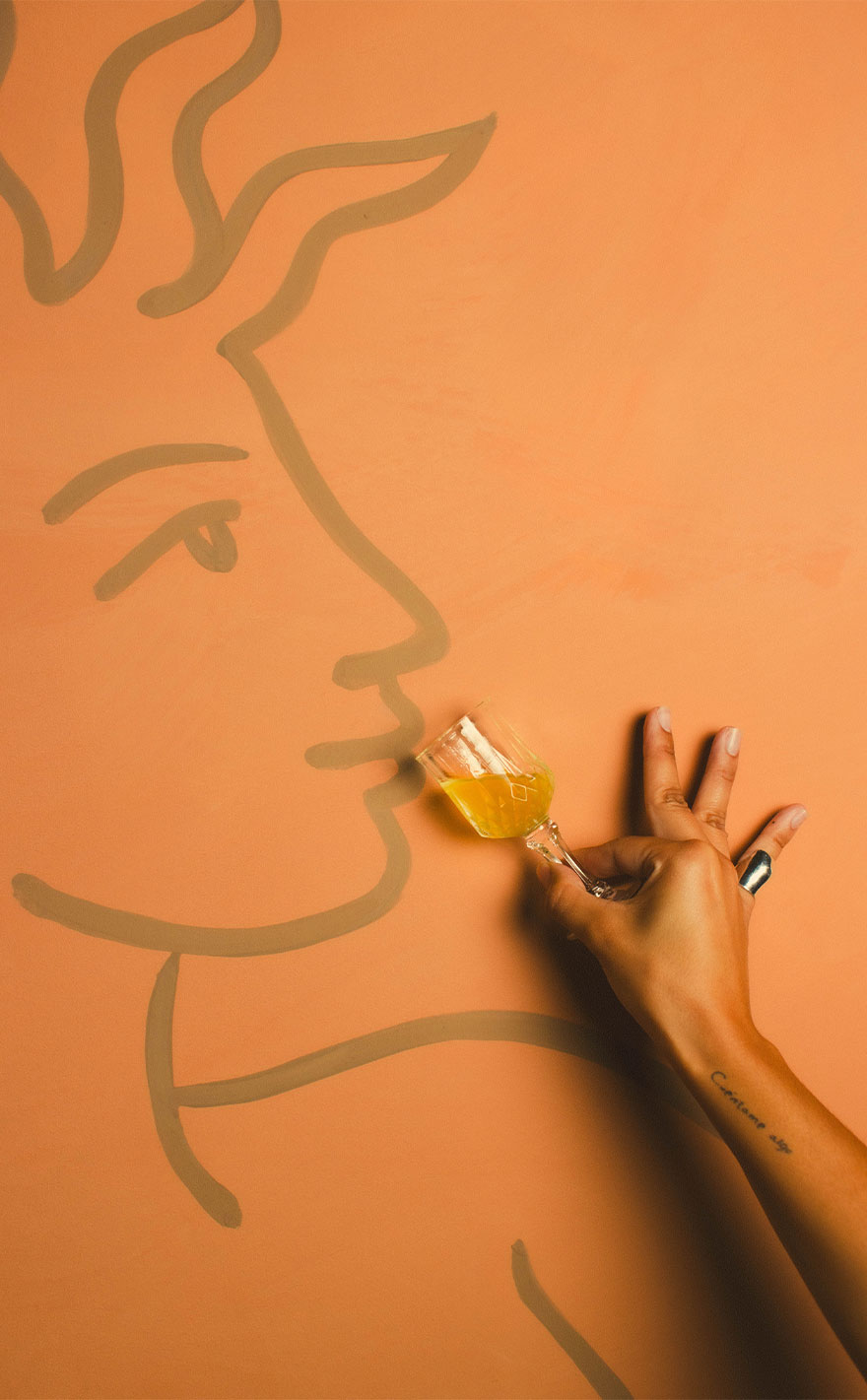 The signature reclining-figure mural over a tufted booth